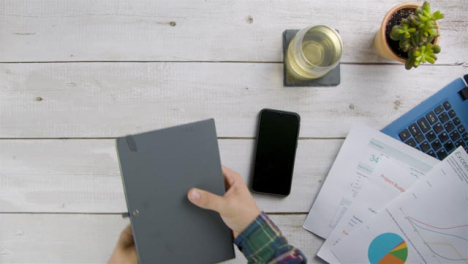 Man-Closing-His-Notebook-On-Desk-and-Taking-It-Away